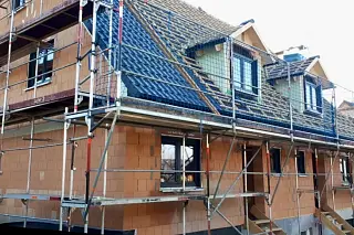 Neubau während des Bauprozesses mit Baugerüst